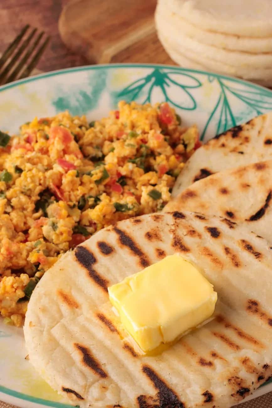 Arepa colombienne grillée servie avec des œufs brouillés à la colombienne