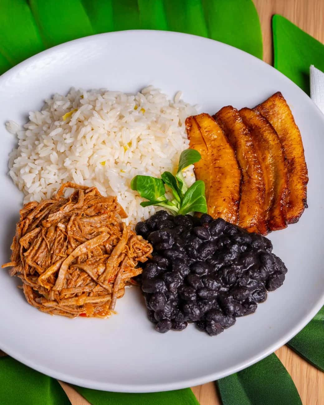 Bandeja paisa colombienne : riz, haricots, viande, plantain et avocat dans une assiette