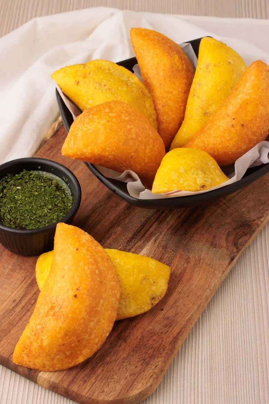 Empanadas colombiennes dorées à la pâte de maïs, servies avec de l'ají vert