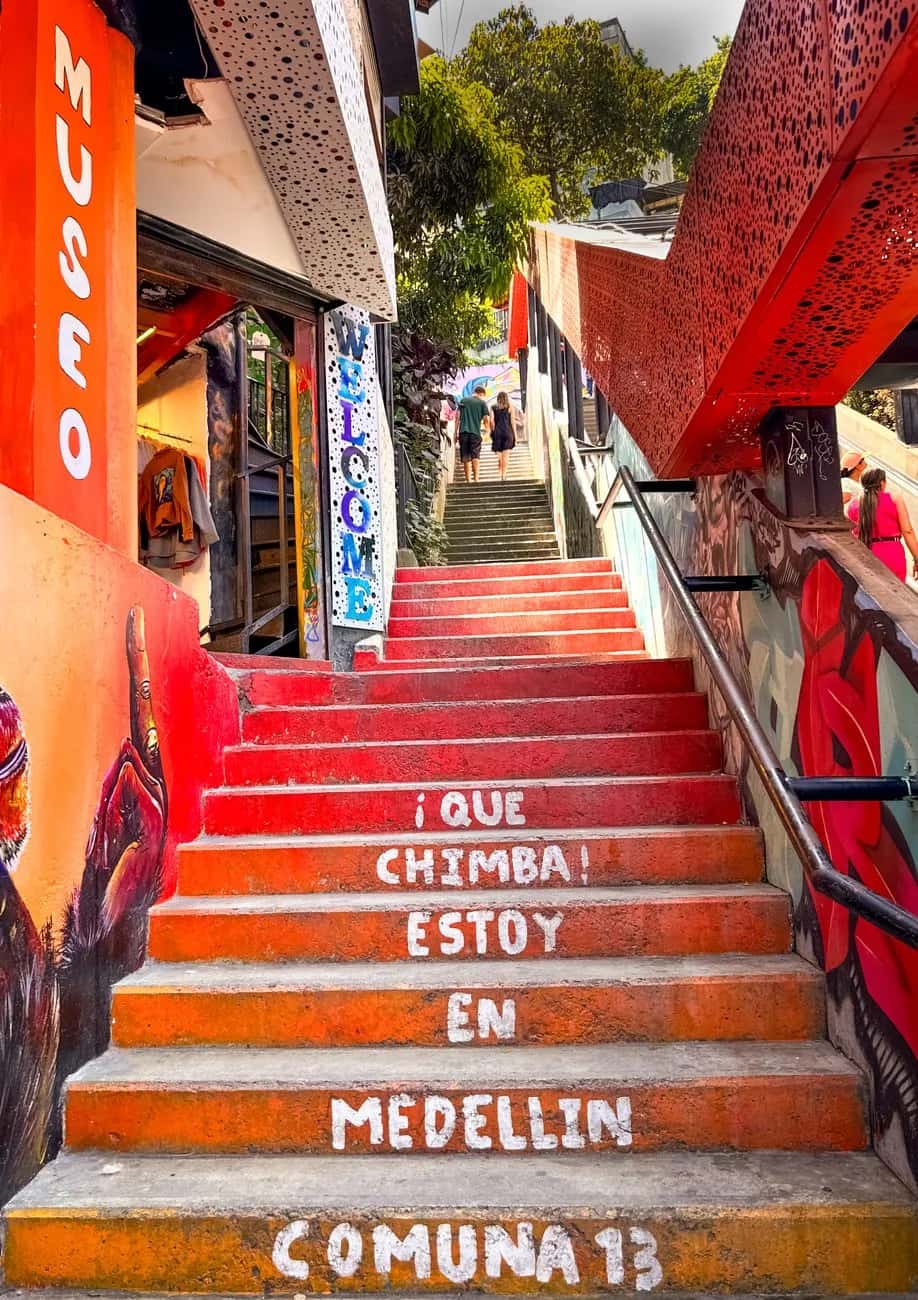 Escaliers colorés de la Comuna 13 à Medellín ornés de street-art, avec l'inscription Comuna 13