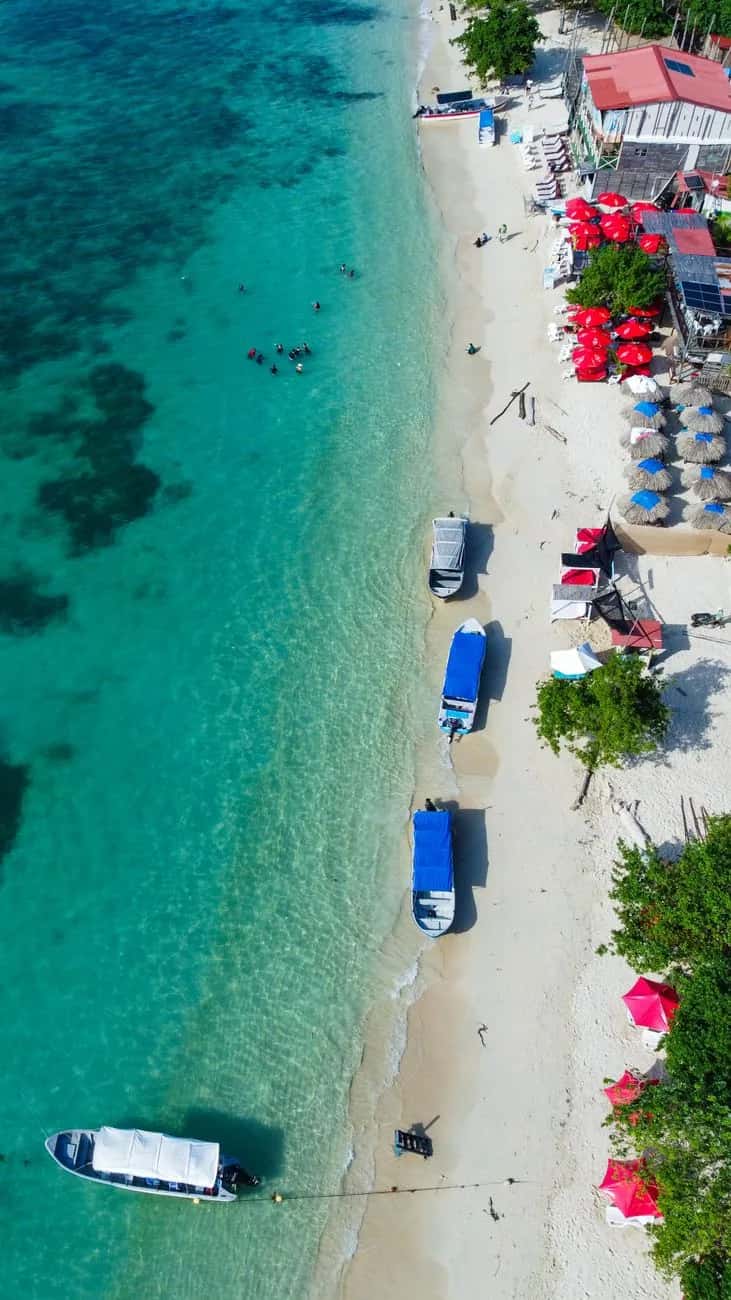 Plage de sable blanc et eau turquoise des Islas del Rosario près de Cartagena, avec bateaux d'excursion