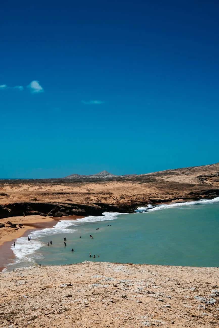 Plage désertique de La Guajira en Colombie, dunes et mer turquoise sous un ciel bleu